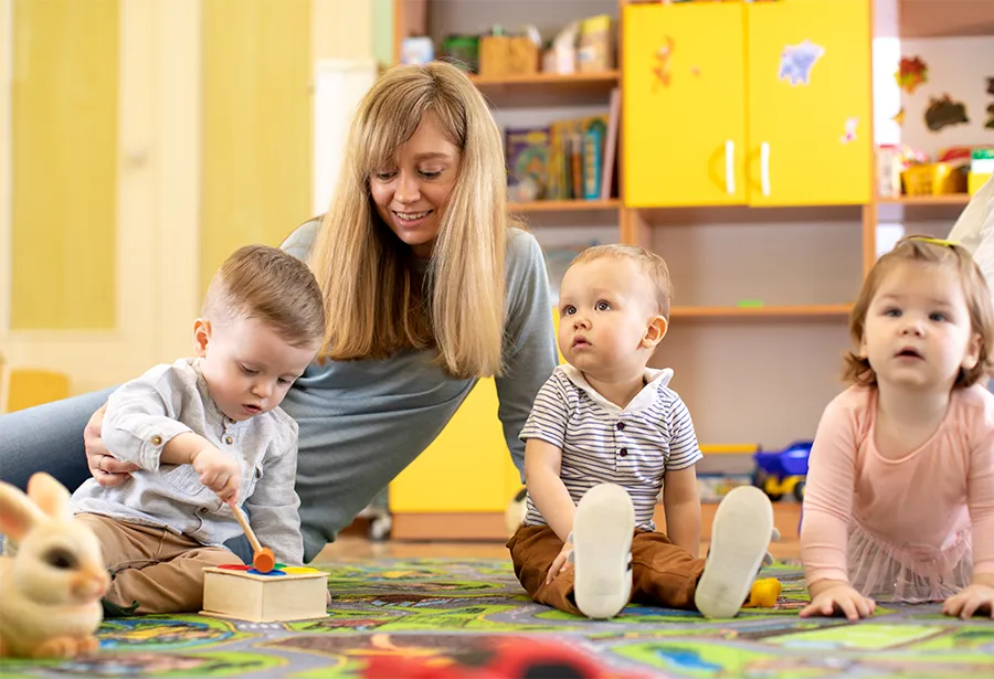Erzieherin kümmert sich um Kinder in der Kindertagesstätte.