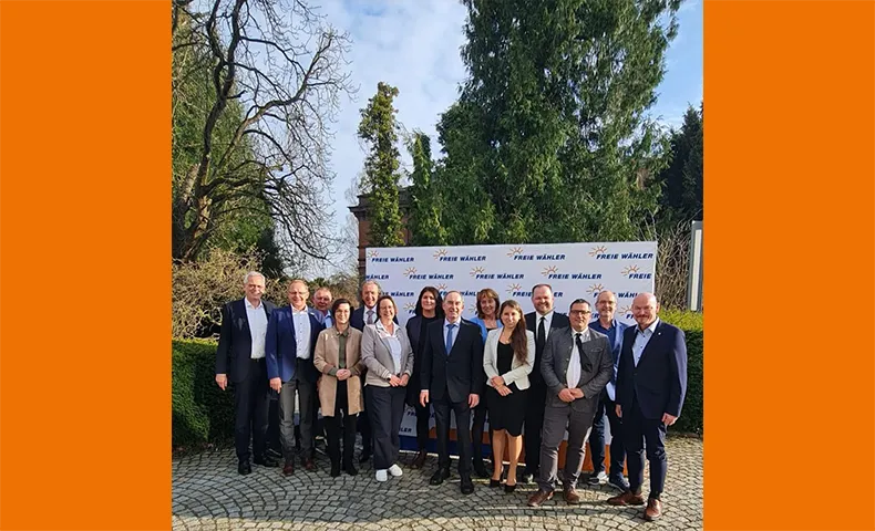 Foto der Landesvorsitzenden vor Logo-Wand.